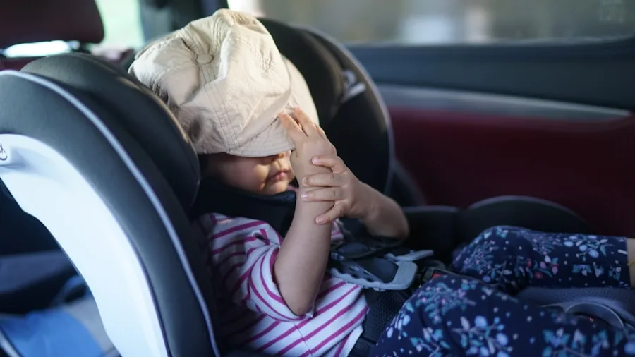 Parent carefully installing infant car seat in vehicle, checking proper fit and height positioning