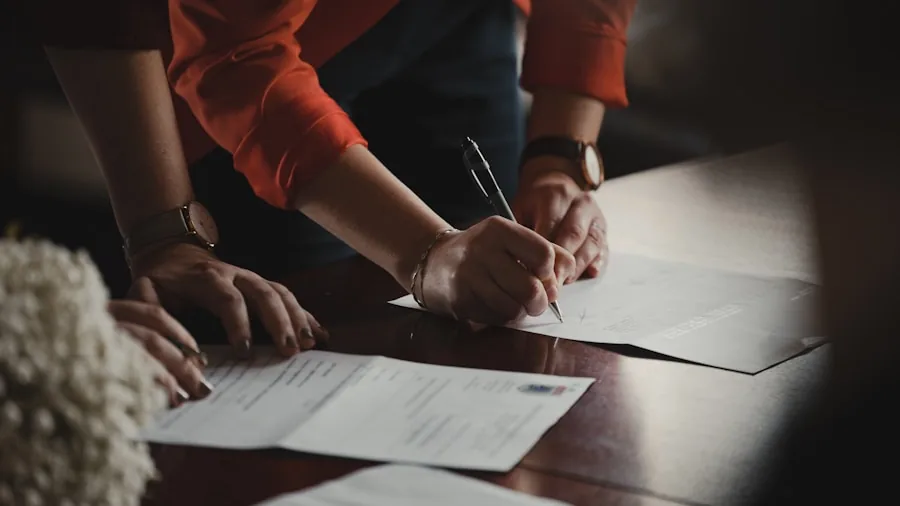 Parent reviewing warranty documents and paperwork at home desk with laptop
