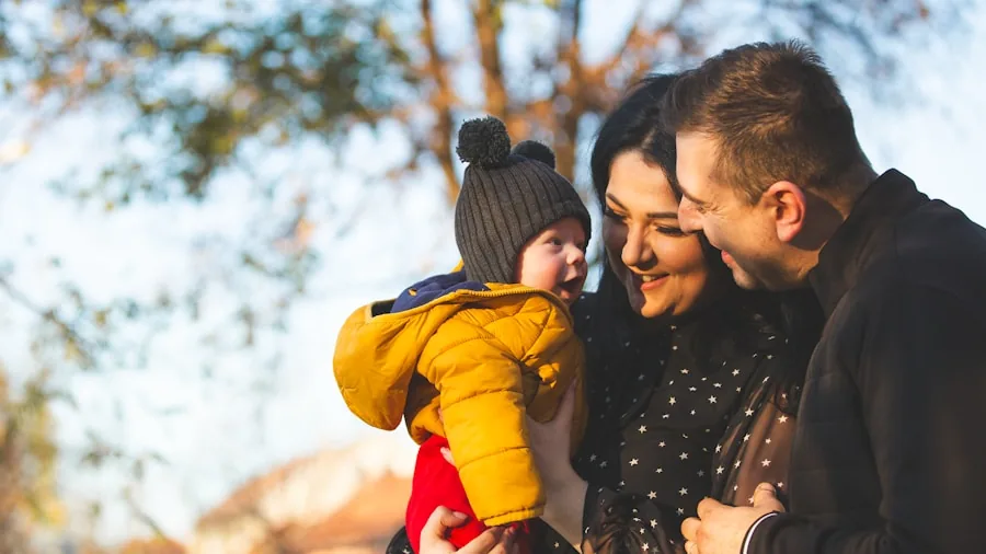 Parent shielding infant from sunlight during outdoor walk, demonstrating UV protection care