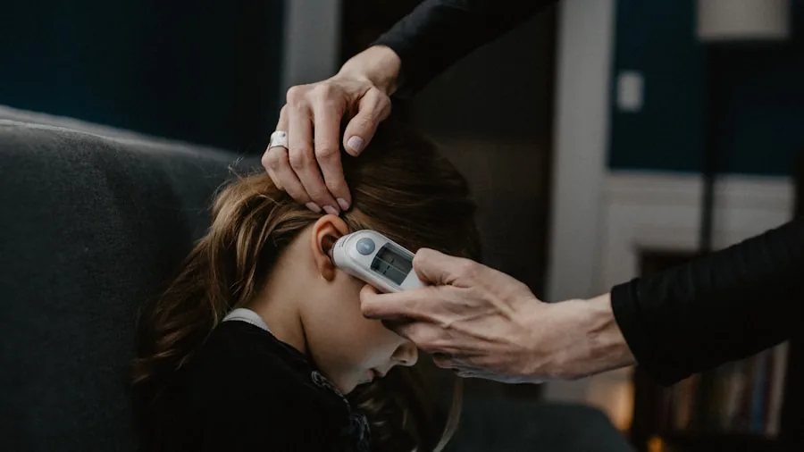 Parent using thermometer to check sick child's temperature at home