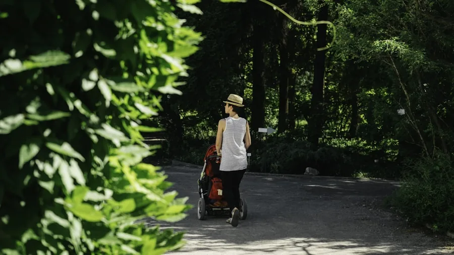 Parent walking with stroller on sunny day in park, child shaded under canopy during outdoor outing