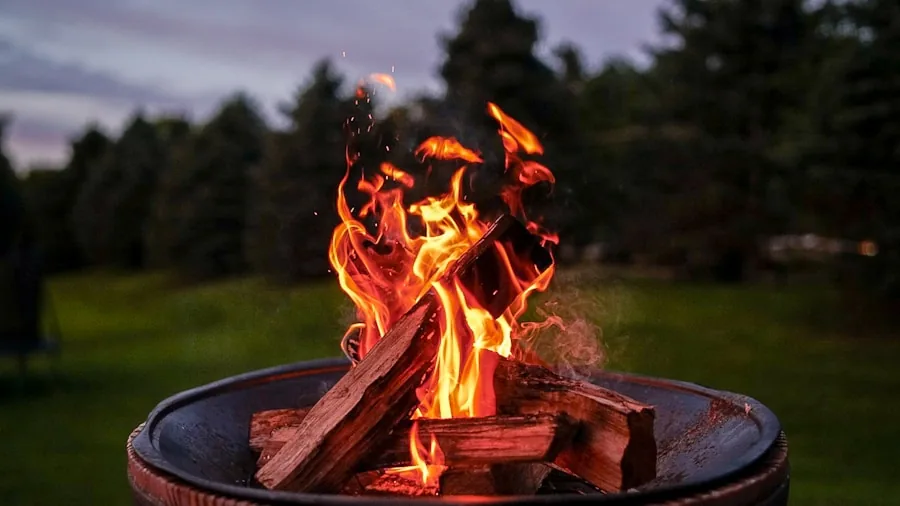 The %product_count% Best Smokeless Fire Pits 2 People gathered around a backyard fire pit on a cool evening, enjoying the warmth and ambiance together