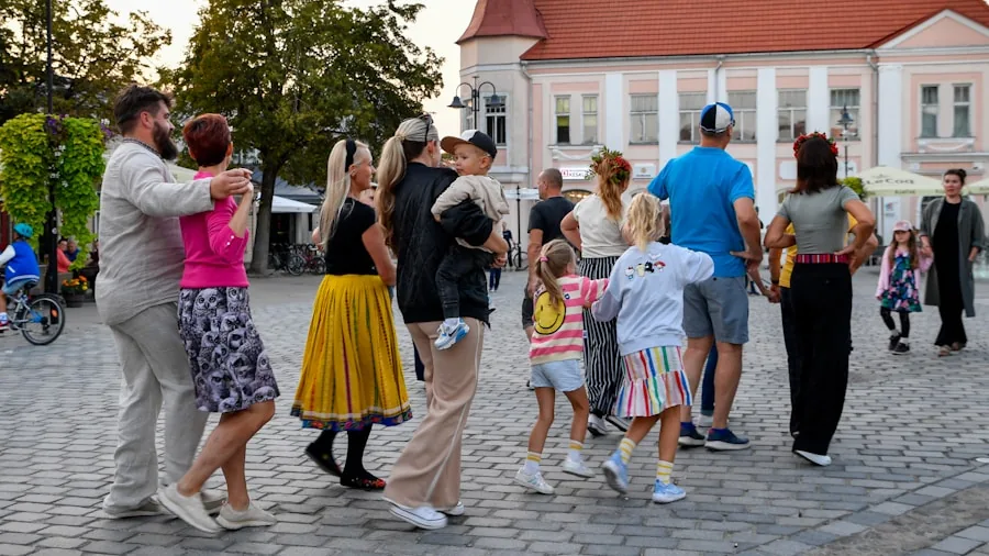 People gathered outside watching entertainment on a summer evening in a backyard setting