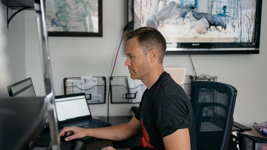 Person adjusting computer monitor height and position at desk for ergonomic comfort during work