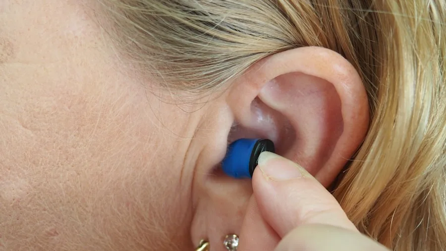 Person adjusting earbuds in ear to find comfortable fit indoors