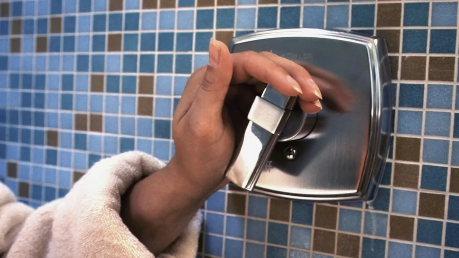 The 13 Best Shower Heads 2 Person adjusting shower head water pressure in bathroom during morning routine