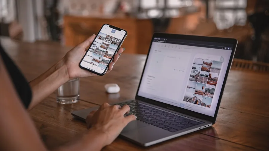 Person at desk switching between laptop and smartphone while working, demonstrating seamless device connectivity
