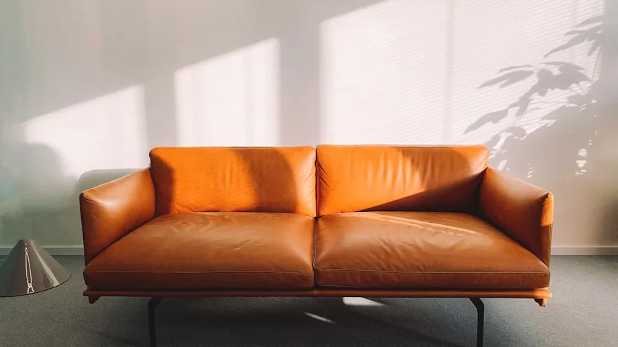 The %product_count% Best Leather Cleaners 2 Person carefully cleaning and maintaining a leather sofa with cloth and cleaner product