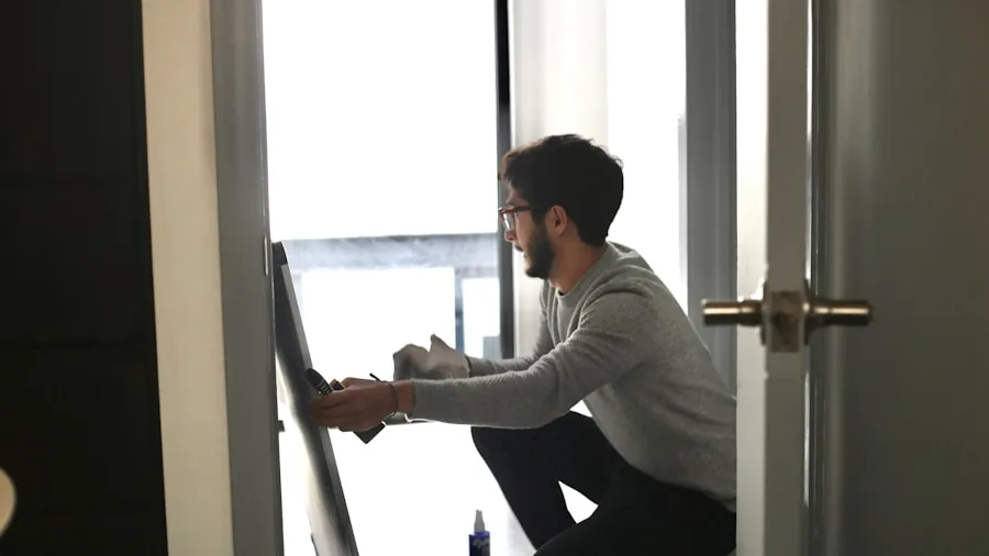 Person carefully mounting large TV on living room wall, checking installation safety and stability