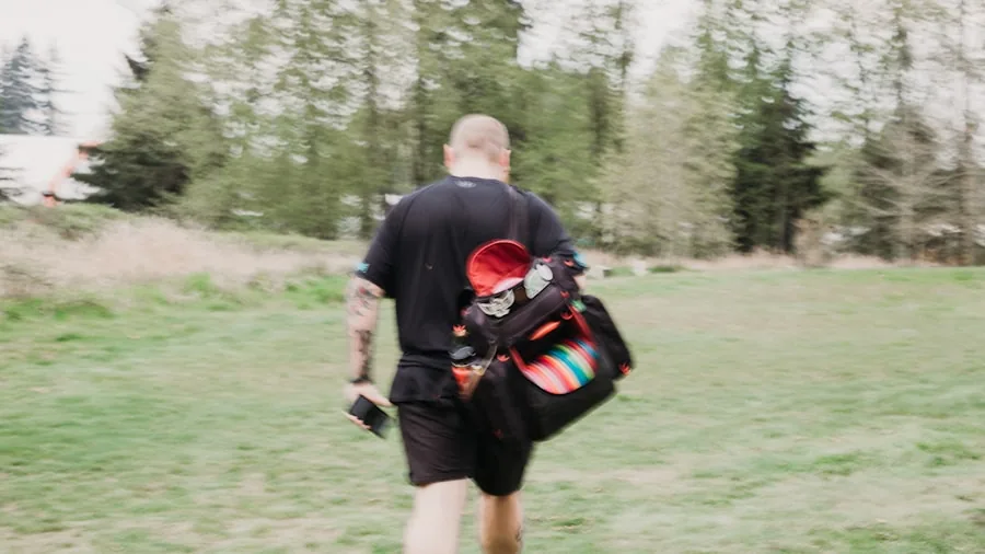 Person carrying portable solar generator while hiking through nature landscape