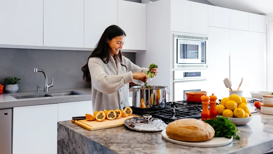 Person checking energy usage while cooking in contemporary kitchen with stainless steel appliances