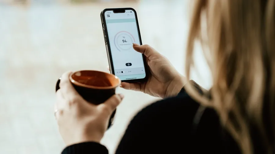Person checking massage gun app on smartphone while using recovery device on leg