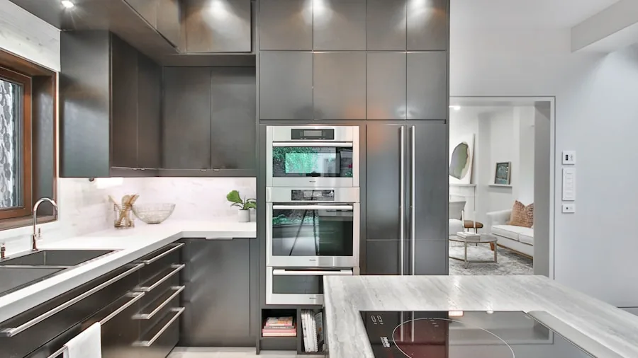Person checking oven temperature while cooking in contemporary kitchen with warm ambient lighting
