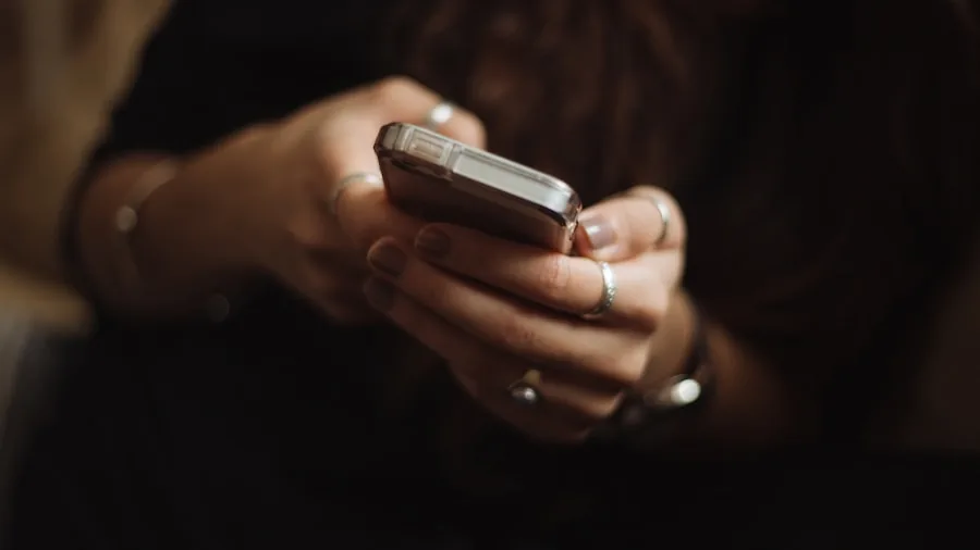 Person checking smartphone battery percentage during daily commute, real-world technology usage