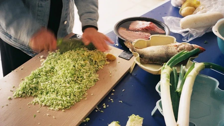 Person chopping fresh vegetables on a wooden cutting board in a bright home kitchen