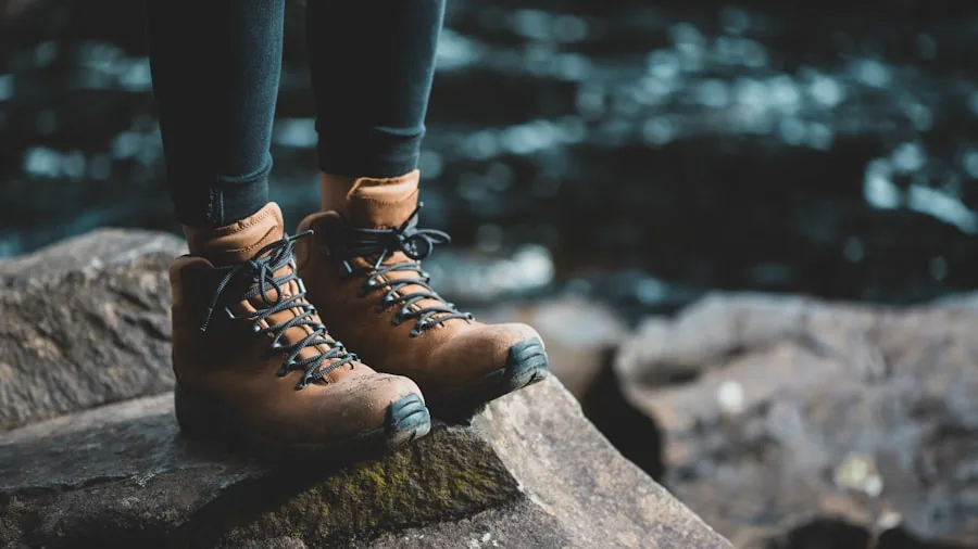 Person cleaning and conditioning hiking boots outdoors in natural light