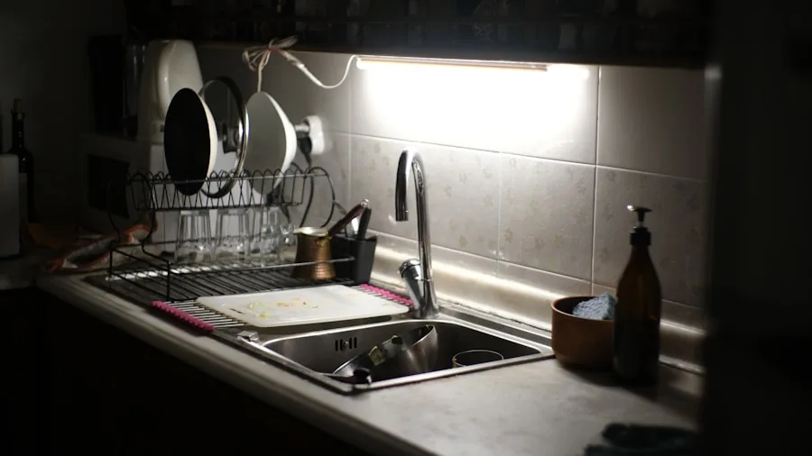 Person cleaning ceramic mugs in a kitchen sink with warm soapy water during daily dishwashing routine