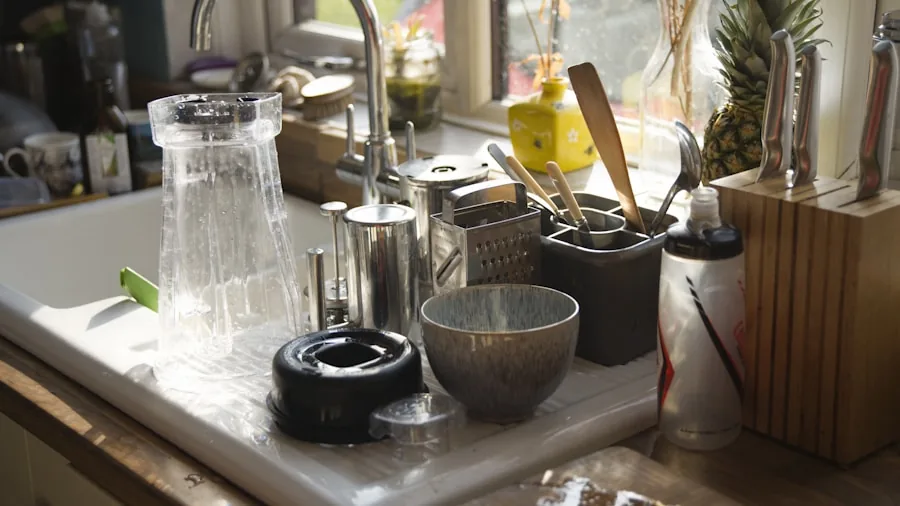 Person cleaning dishes in a bright kitchen sink with soapy water and natural light