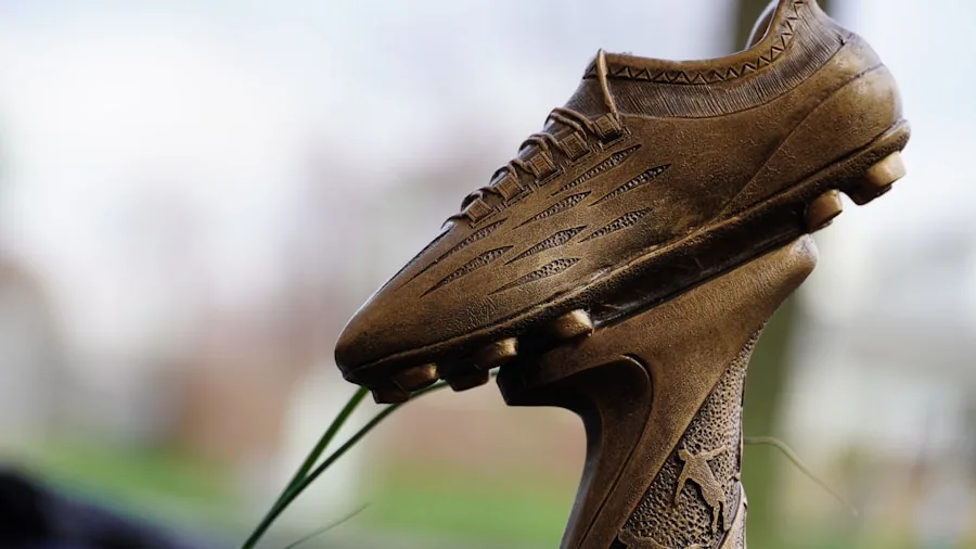Person cleaning muddy football cleats with brush and water after game