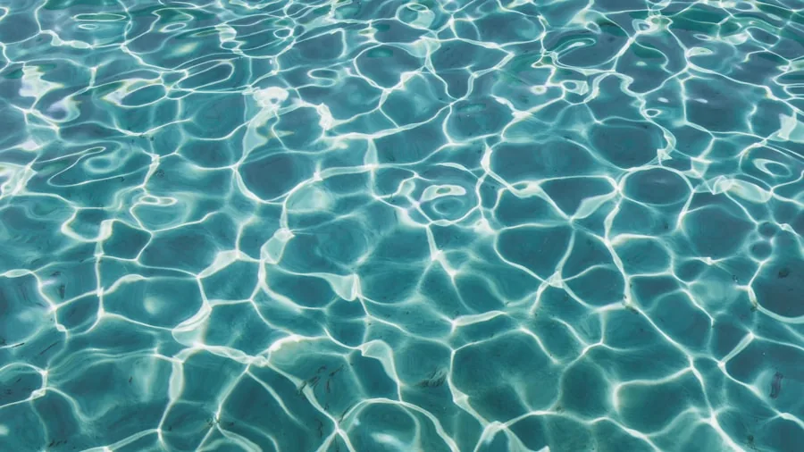 The %product_count% Best Pool Cleaners 4 Person cleaning pool walls and waterline with brush during routine pool maintenance