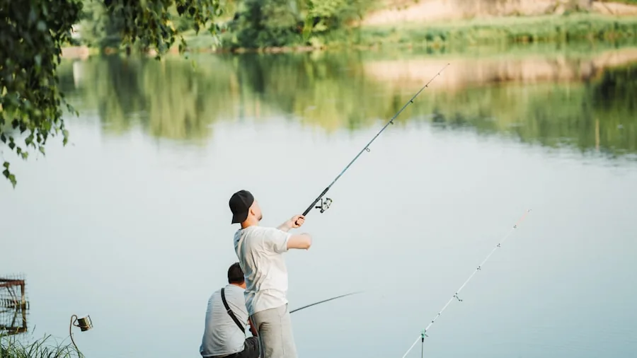Person comparing fishing rods while standing by a lake, choosing equipment for bass fishing