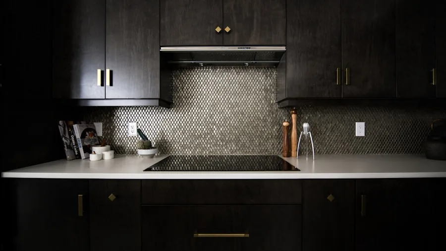 Person cooking on induction cooktop in contemporary kitchen with stainless steel cookware