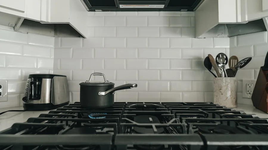 Person cooking with stainless steel pots and pans on a kitchen stovetop during meal preparation