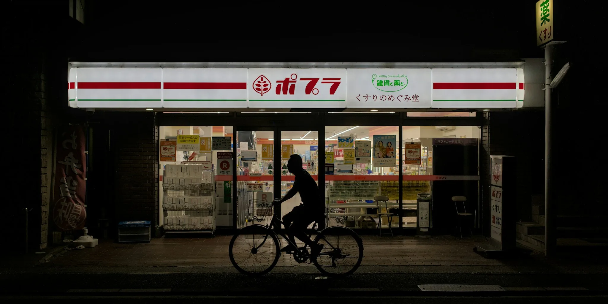 Person cycling on dark street at night with illuminated bike lights