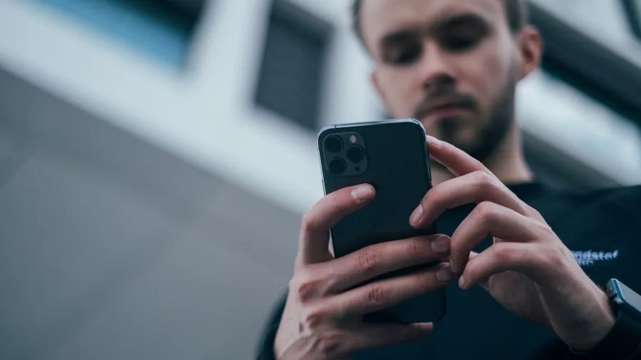The %product_count% Best Phone Cases 2 Person dropping a smartphone on pavement, demonstrating phone case protection and durability in real-world scenario