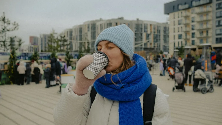 Person enjoying a cold drink during outdoor morning commute in natural daylight setting