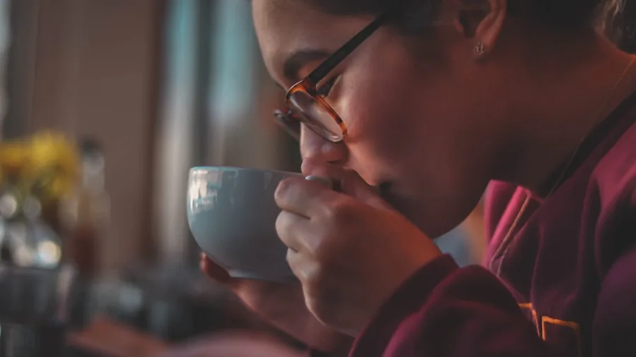 Person enjoying a quick cup of coffee in a modern kitchen during their morning routine