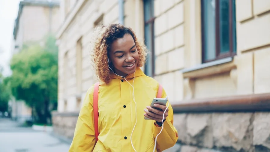 Person enjoying music outdoors with earbuds, lifestyle scene