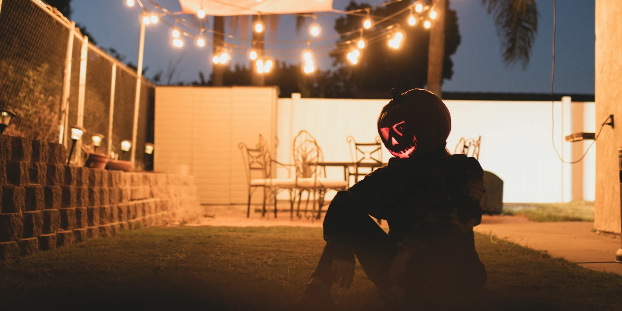 Person enjoying outdoor movie night with mini projector in backyard
