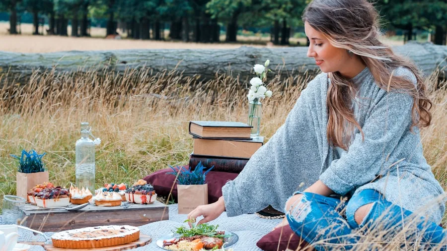 Person enjoying portable music outdoors during a relaxing picnic gathering with friends