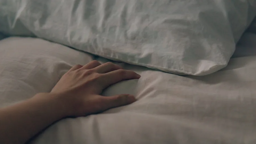 Person examining pillows on bed while selecting the right size and shape for comfortable sleep