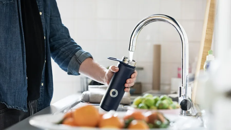The 12 Best Under-Sink Water Filters 2 Person examining water filter packaging and certification standards in kitchen under sink area