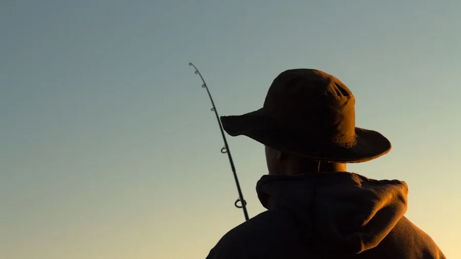 Person fishing by water in natural outdoor setting wearing sunglasses