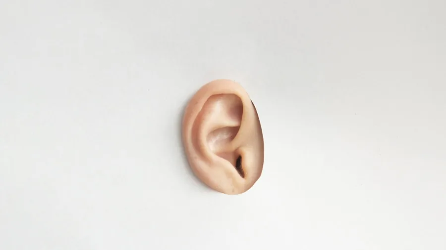 Person focusing intently while listening to someone speak in a quiet environment