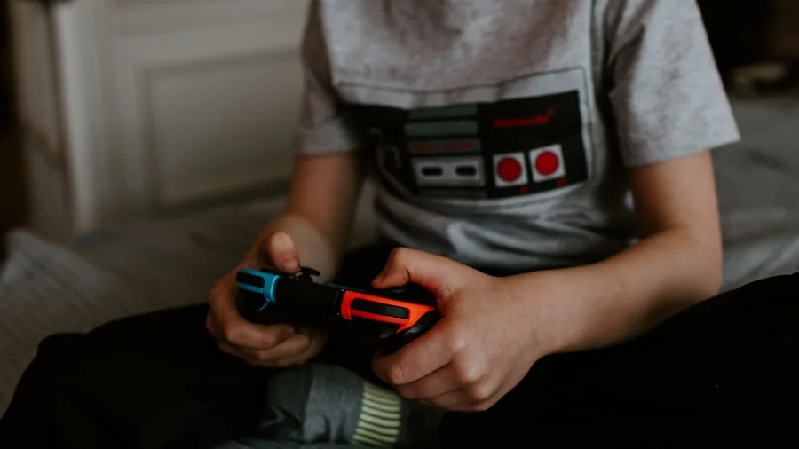 Person gaming with controller experiencing durability and reliability during extended gameplay session