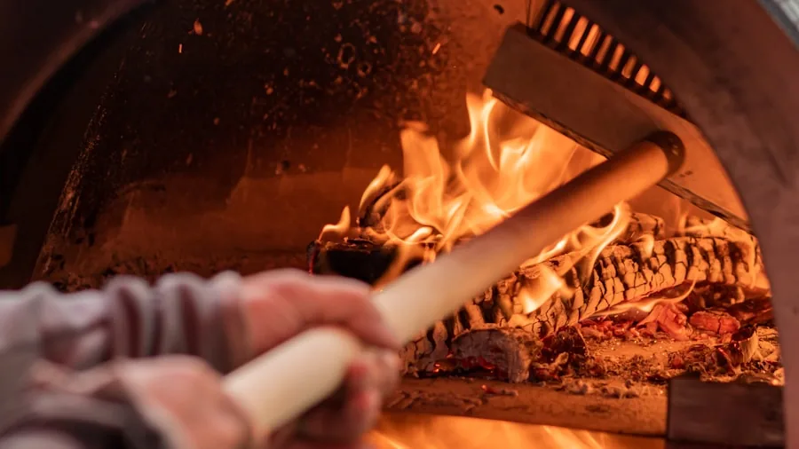 Person gently cleaning the interior of a pizza oven with a soft brush after cooking