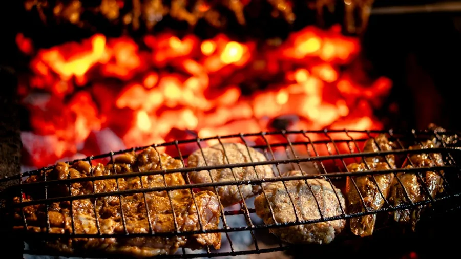 Person grilling food on a charcoal kettle grill in a backyard setting during daytime