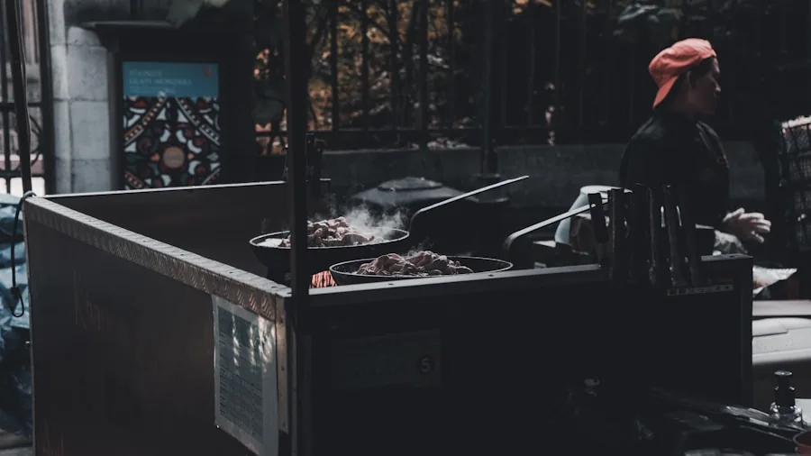 Person grilling meat outdoors on a backyard barbecue grill during daytime