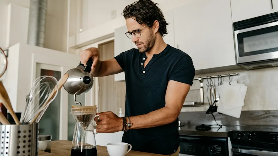 Person grinding fresh coffee beans in kitchen for espresso preparation