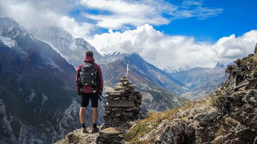 Person hiking on mountain trail with backpack during daytime outdoor adventure