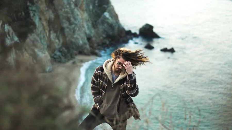 Person holding selfie stick taking photo in outdoor windy conditions while standing confidently
