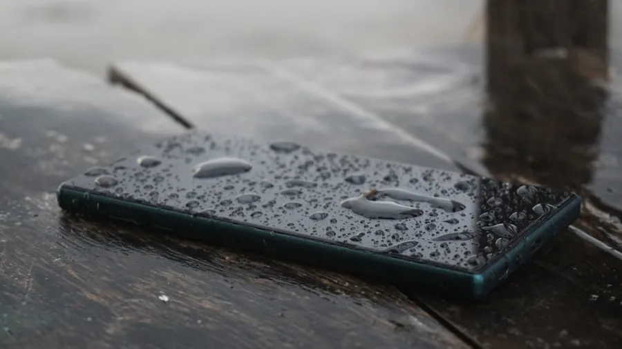 The %product_count% Best Smartphones 5 Person holding smartphone in rainy weather, demonstrating water resistance durability in everyday conditions