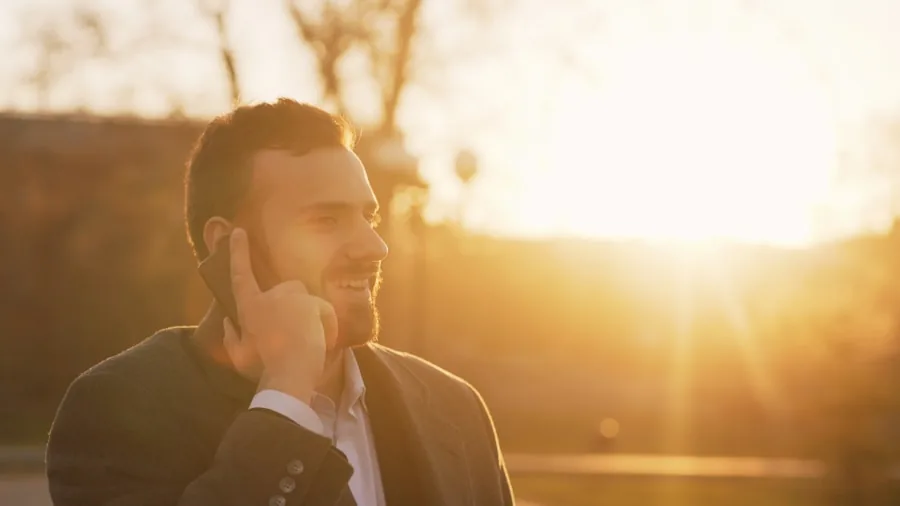 The %product_count% Best Motorola Phones 2 Person holding smartphone outdoors in bright daylight, reading content on screen in sunny environment