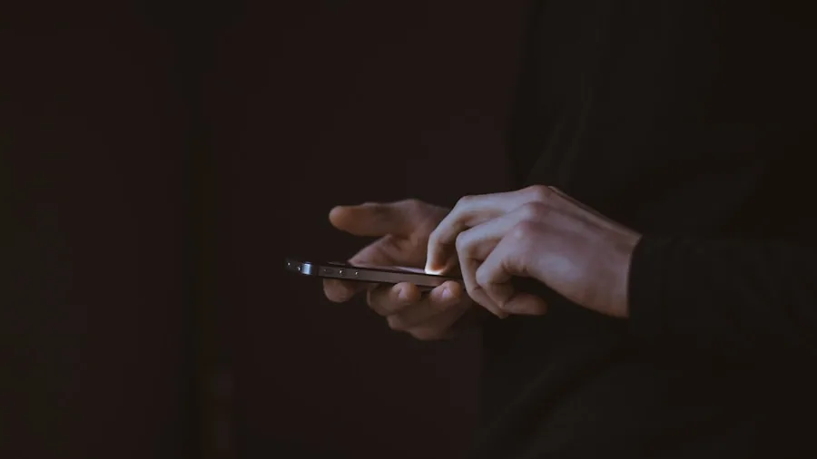The %product_count% Best Mesh Routers 5 Person holding smartphone while managing home network settings through mobile app interface