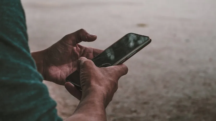Person holding smartphone while scrolling, natural outdoor lighting highlighting display screen