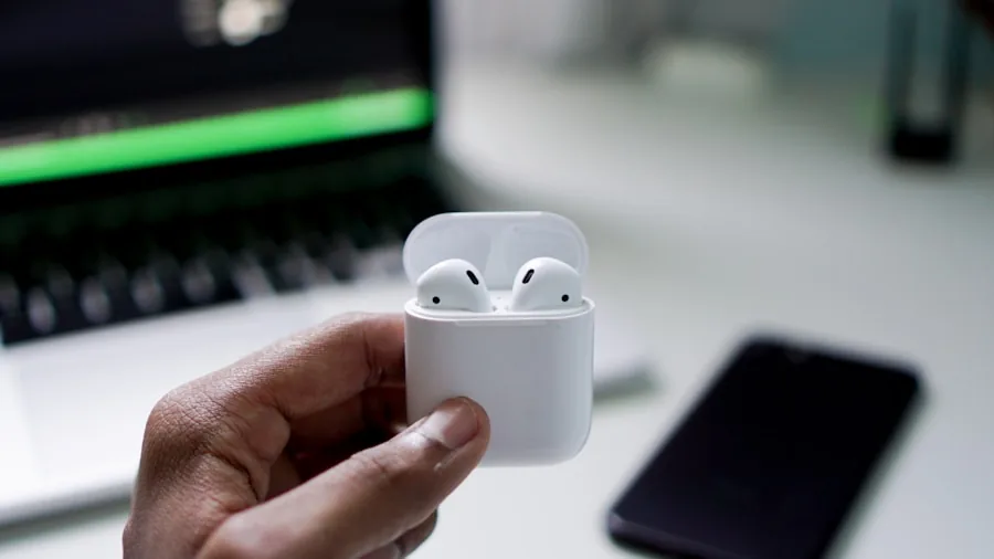 Person holding wireless earbuds near charging case during daily routine, lifestyle scene